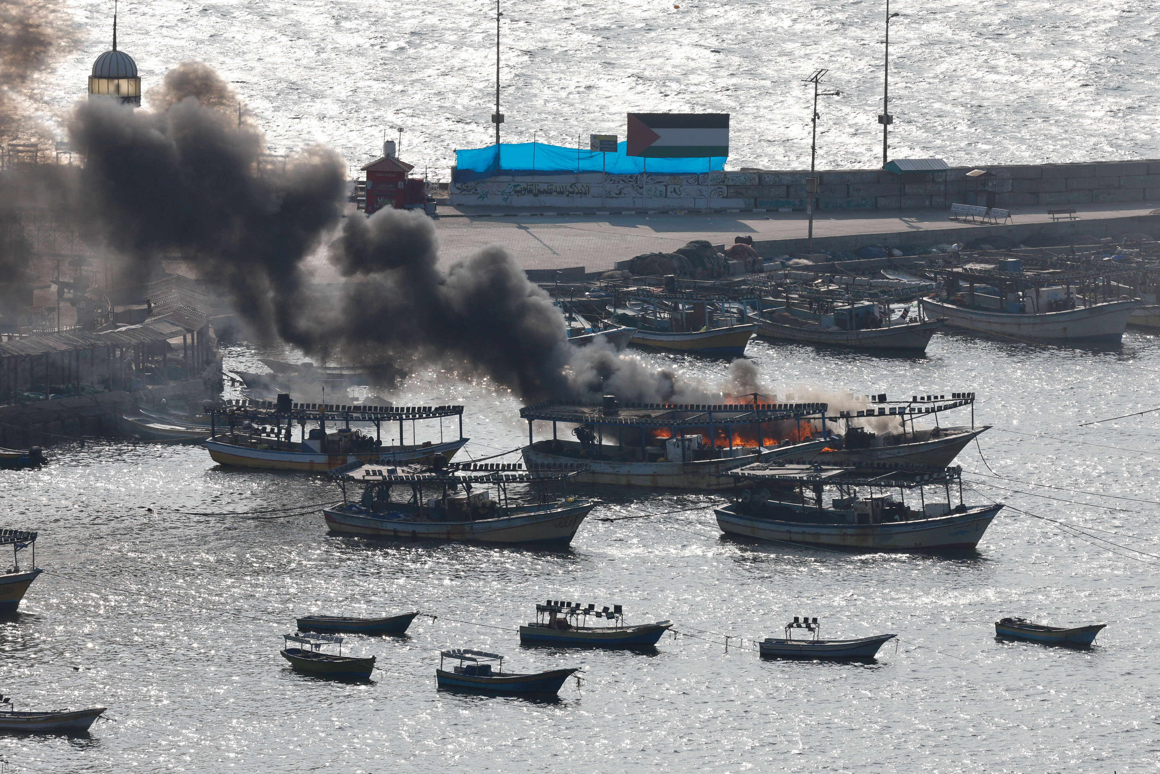 Smoke billows from a boat following Israeli strikes, at Port of Gaza